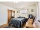 Cozy bedroom with hardwood floors, a checkered comforter, a mirrored closet, and a dresser at 4585 Garrison St, Wheat Ridge, CO 80033