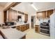 Cozy kitchen with wooden cabinets, tile countertops, stainless steel oven, and a view through the window at 4585 Garrison St, Wheat Ridge, CO 80033