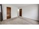 Bedroom showcasing neutral carpet and two doors, providing access and storage at 14192 E Colorado Dr # 102, Aurora, CO 80012