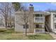 Charming condo with a stone chimney, two balconies, a well-kept lawn, and stairs to the upper level at 14192 E Colorado Dr # 102, Aurora, CO 80012