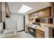 Bright kitchen with a skylight, wood cabinets, and functional cooking appliances at 14192 E Colorado Dr # 102, Aurora, CO 80012