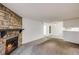 Cozy living area featuring a stone fireplace, carpet, neutral walls, and open access to other rooms at 14192 E Colorado Dr # 102, Aurora, CO 80012