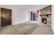 Spacious living area with stone fireplace, a sliding glass door with curtains, and access to a side door at 14192 E Colorado Dr # 102, Aurora, CO 80012
