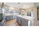 Island kitchen with gray cabinets, white quartz countertops, and stainless steel appliances at 11300 Whooping Crane Dr, Parker, CO 80134