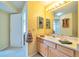 Bright bathroom featuring a wooden vanity and mirror with decorative hanging cabinet at 6001 S Yosemite St # B203, Greenwood Village, CO 80111