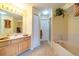 Well-lit bathroom featuring a vanity, large mirror, soaking tub, and separate shower at 6001 S Yosemite St # B203, Greenwood Village, CO 80111