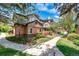 View of townhouse featuring brick accents, landscaping, and inviting walkway at 6001 S Yosemite St # B203, Greenwood Village, CO 80111