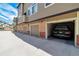 Row of garages, with one open showing a parked SUV, in a well maintained townhouse community at 6001 S Yosemite St # B203, Greenwood Village, CO 80111