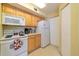 Efficient kitchen featuring white appliances and light wood cabinets at 6001 S Yosemite St # B203, Greenwood Village, CO 80111