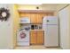 Kitchen with white appliances and light wood cabinets at 6001 S Yosemite St # B203, Greenwood Village, CO 80111