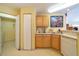 Kitchen with light wood cabinetry, laminate countertops, and white appliances at 6001 S Yosemite St # B203, Greenwood Village, CO 80111