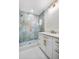 Bathroom features updated tile in the shower with lovely white vanity and golden fixtures at 6882 Quail St, Arvada, CO 80004