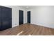 Bright bedroom showcasing hardwood floors and stylish, contrasting dark-colored doors and trim at 6882 Quail St, Arvada, CO 80004