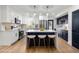 Modern kitchen features white cabinetry, stainless steel appliances, and a stylish island with seating at 6882 Quail St, Arvada, CO 80004