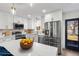 White kitchen boasts an island and stainless steel appliances at 6882 Quail St, Arvada, CO 80004