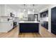 Bright kitchen features an island, stainless steel appliances, and white and navy cabinets at 6882 Quail St, Arvada, CO 80004