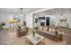 Open-concept living room and dining area with hardwood floors and abundant natural light at 6882 Quail St, Arvada, CO 80004