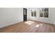 Sunlit living room featuring new floors, white walls, and an exterior door leading outdoors at 6882 Quail St, Arvada, CO 80004