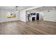 Open-concept living room showcasing hardwood floors and seamless flow into dining and kitchen spaces at 6882 Quail St, Arvada, CO 80004