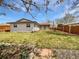Green backyard showcasing a covered patio, lawn, wood fencing and a garden at 206 River Rd, Platteville, CO 80651