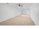 Spacious finished basement featuring neutral carpet, ceiling fans, and natural light from the egress windows at 206 River Rd, Platteville, CO 80651