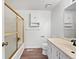 Bathroom featuring a shower with glass door, white cabinets, and a modern sink at 206 River Rd, Platteville, CO 80651