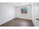 Minimalist bedroom featuring a large window and hardwood floors at 206 River Rd, Platteville, CO 80651
