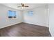 Bright bedroom with hardwood floors, two windows, and neutral paint at 206 River Rd, Platteville, CO 80651