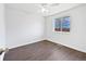 Bedroom with hardwood floors, a ceiling fan, and a large window with a backyard view at 206 River Rd, Platteville, CO 80651
