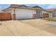 View of house with a large driveway and an attached two-car garage at 206 River Rd, Platteville, CO 80651