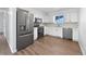 Modern kitchen featuring stainless steel appliances, white cabinets, and hardwood floors at 206 River Rd, Platteville, CO 80651