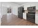 Modern kitchen featuring stainless steel appliances and hardwood floors at 206 River Rd, Platteville, CO 80651