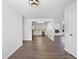 Open-concept living room features hardwood floors, white walls, and a view of the kitchen with stainless steel appliances at 206 River Rd, Platteville, CO 80651