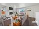 Bright living room with white brick fireplace, hardwood floors, and large picture window at 206 River Rd, Platteville, CO 80651