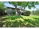 Exterior of home with a spacious backyard, mature trees, and a deck at 5616 S Kenton Ct, Englewood, CO 80111