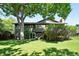 Exterior of home with a spacious backyard, mature trees, and a sliding glass door at 5616 S Kenton Ct, Englewood, CO 80111