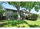 Exterior of home with a spacious backyard, mature trees, and a deck at 5616 S Kenton Ct, Englewood, CO 80111