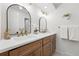 Bathroom featuring double sinks, elegant mirrors, and modern lighting fixtures at 5616 S Kenton Ct, Englewood, CO 80111