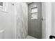 Shower with a vertical pattern of two-toned tile and built-in shower niche with stacked subway tile at 5616 S Kenton Ct, Englewood, CO 80111