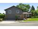 Charming two-story home featuring a well-manicured lawn, mature trees, and a covered front entrance at 5616 S Kenton Ct, Englewood, CO 80111