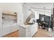 Modern kitchen with white cabinetry, stainless steel appliances, and an open layout leading to the dining area at 5616 S Kenton Ct, Englewood, CO 80111
