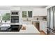 Bright kitchen with stainless steel appliances, white cabinets, sleek countertops, and modern fixtures at 5616 S Kenton Ct, Englewood, CO 80111