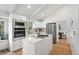 Modern kitchen featuring white cabinets, stainless steel appliances, and a functional center island at 5616 S Kenton Ct, Englewood, CO 80111