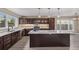 Modern kitchen with stainless appliances, large island, dark wood cabinets, and pendant lighting at 2008 S Galapago St, Denver, CO 80223