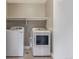 Well-lit laundry room featuring modern, front-load washer and dryer with convenient shelf at 2008 S Galapago St, Denver, CO 80223