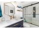 Stylish bathroom vanity featuring a gold faucet, quartz countertops and shower with a glass door at 6600 E Mississippi Ave # 7, Denver, CO 80224