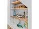 Close-up of built-in shelves displaying decorative items adding charm and character to the space at 6600 E Mississippi Ave # 7, Denver, CO 80224