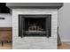 Close-up of a modern fireplace with stone surround and open glass doors at 6600 E Mississippi Ave # 7, Denver, CO 80224