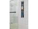 Close up of the shower which features a product shelf and white tiling at 6600 E Mississippi Ave # 7, Denver, CO 80224