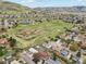 Aerial view of neighborhood and large community park with walking trails, grassy fields, and tennis courts at 320 Orion St, Golden, CO 80401